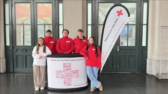 Junge Menschen stehen um einen Dialogstand.