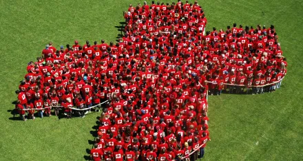 Eine Menschengruppe in Kreuzform