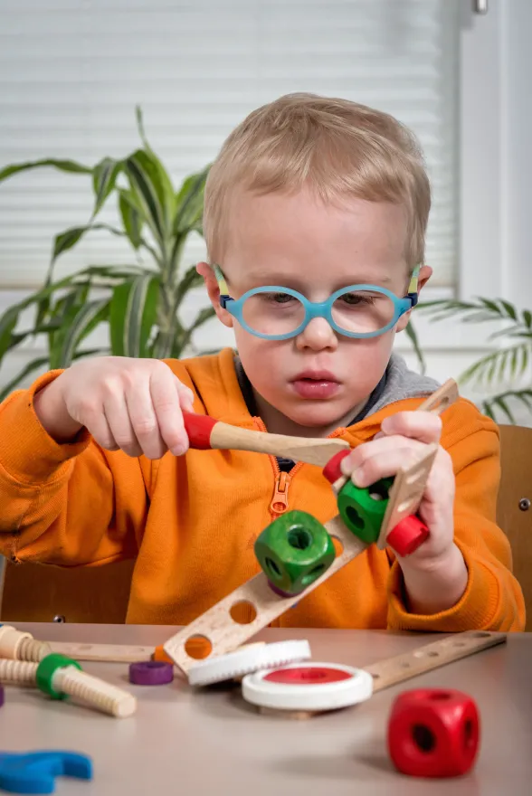 Ein Kind baut ein Spielzeug aus Holz