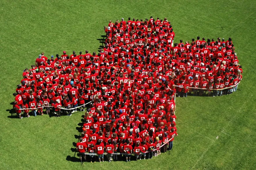 Eine Menschengruppe in Kreuzform