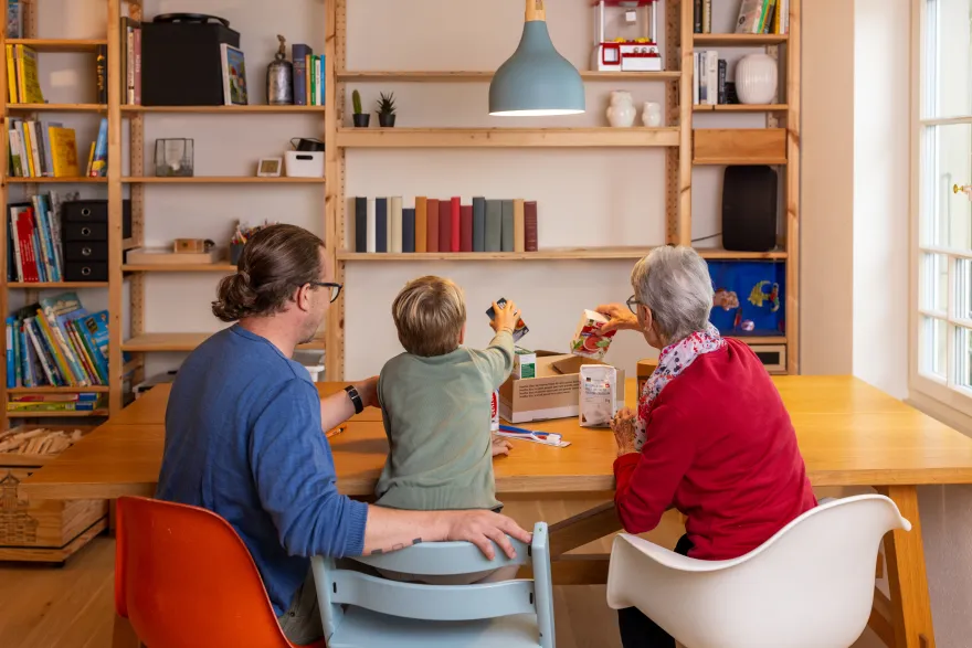 Eine Familie packt ein Paket für 2x Weihnachten